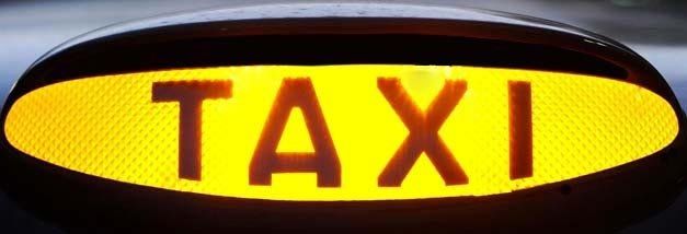 A yellow sign that says taxi on it